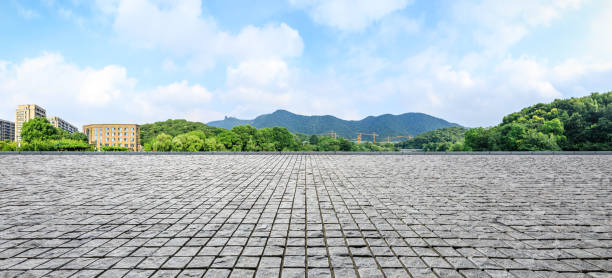 istock Rough stone floor and green mountain with sky landscape 1141572424