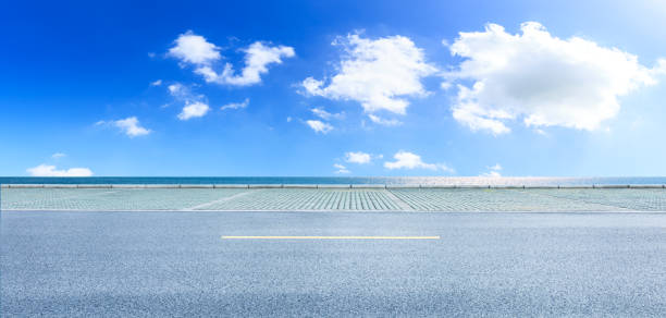 istock Asphalt road and blue sea with sky background 1141573170