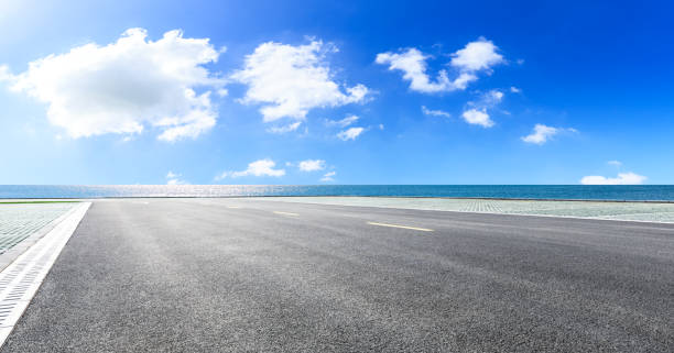 istock Asphalt road and blue sea with sky background 1141573199