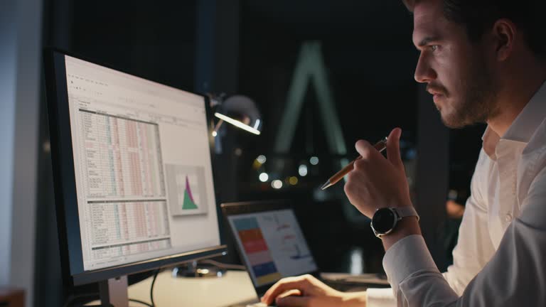 Handsome entrepreneur analyzing data on computer