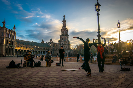 Seville, Andalucia, Spain - January 08, 2018: Photo taken in the magnificent Plaza de España in Seville. In the image we see flamenco dancers and a local band. There are in the background several tourists enjoying the presentation that very well portrays the Spanish culture.