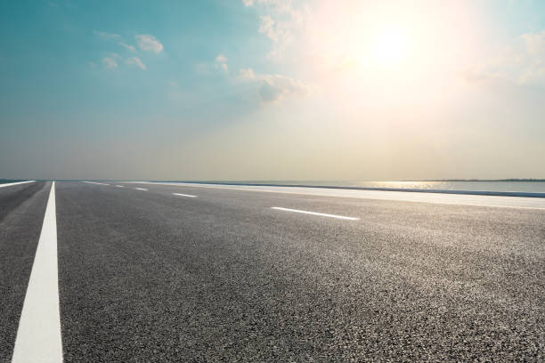 istock Asphalt road and blue sea with sky background 1141573963