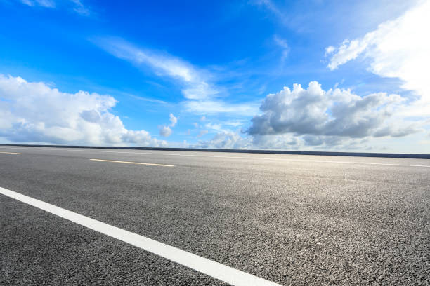 istock Asphalt road ground and blue sky with white clouds scene 1141573965
