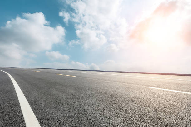 istock Asphalt road ground and blue sky with white clouds scene 1141574761