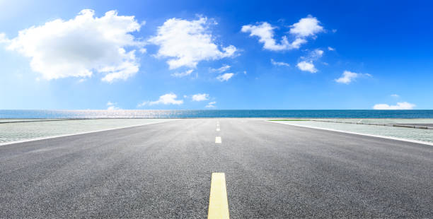 istock Asphalt road and blue sea with sky background 1141574854