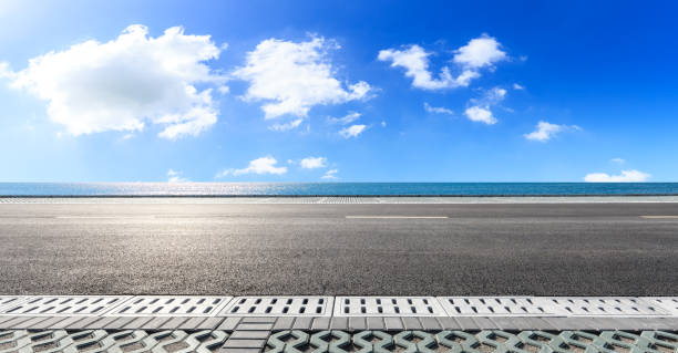 istock Asphalt road and blue sea with sky background 1141574900