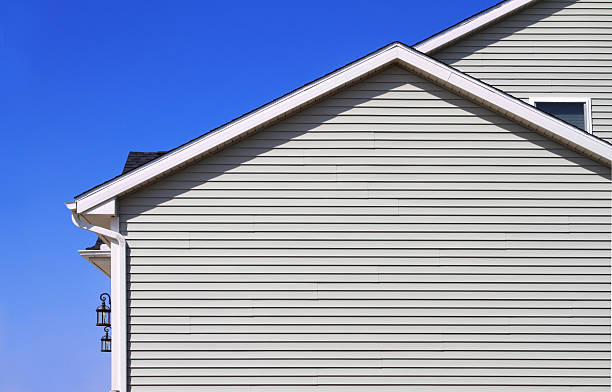Gray back of home with slats and vinyl white gutters New home with vinyl siding and gutters with blue sky in the  background siding stock pictures, royalty-free photos & images