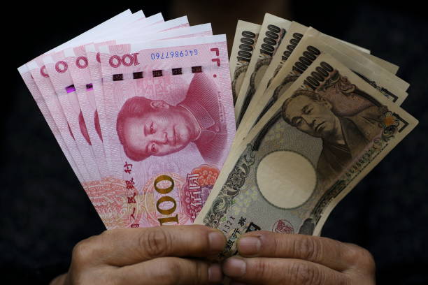 istock CNY (Chinese Yuan) 100 banknotes and JPY(Japanese Yen) 10,000 banknotes 1141577156