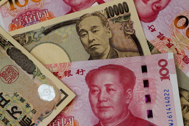 istock CNY (Chinese Yuan) 100 banknotes and JPY(Japanese Yen) 10,000 banknotes 1141577157