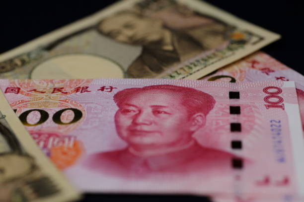 istock CNY (Chinese Yuan) 100 banknotes and JPY(Japanese Yen) 10,000 banknotes 1141577158