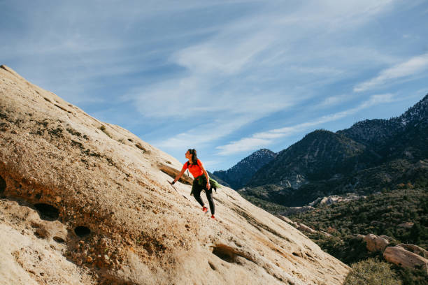 Strong young woman rock climbing in Utah on a beautiful fall day