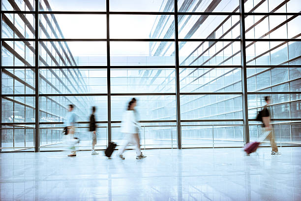istock Blurred Travellers Pulling Suitcase Along Hallway in Airport 114158310
