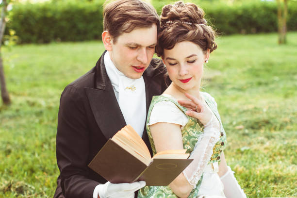 istock couple reading a book sitting on the grass 1141584518