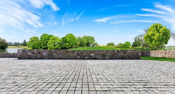 istock Rough stone floor and green woods with sky background 1141602351