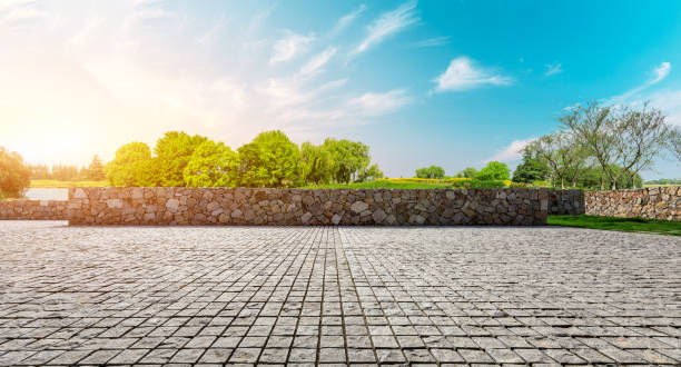 istock Rough stone floor and green woods with sky background 1141603354