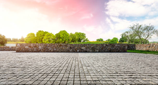 istock Rough stone floor and green woods with sky background 1141603400