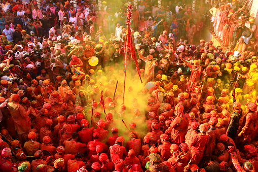 The Gopas of Barsana play Holi with the Gopis of Nandgaon during the Lathmar Holi Festival in Nandgaon. The occasion is marked by singing of devotional and folk songs known as the \