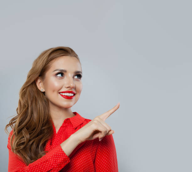 istock Pretty model pointing finger and smiling on white background 1141606537
