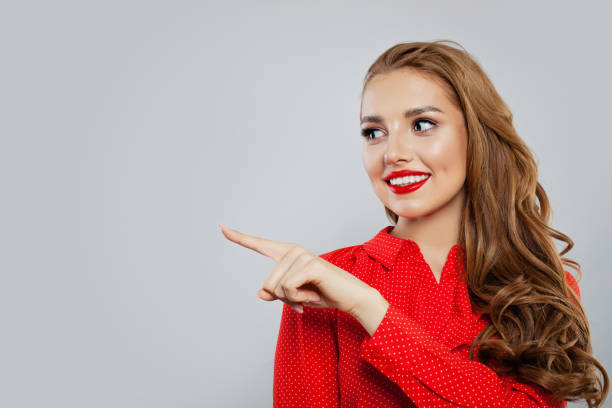istock Happy woman pointing and looking at empty copy space on white background 1141606540