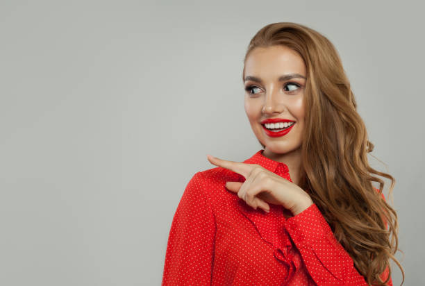istock Laughing model woman pointing finger on white background 1141606549