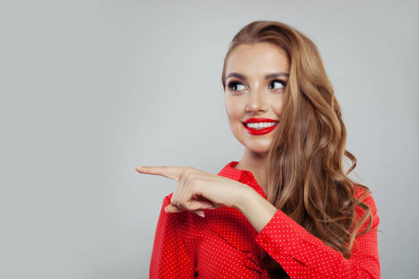 istock Successful model woman pointing aside on white background 1141606559