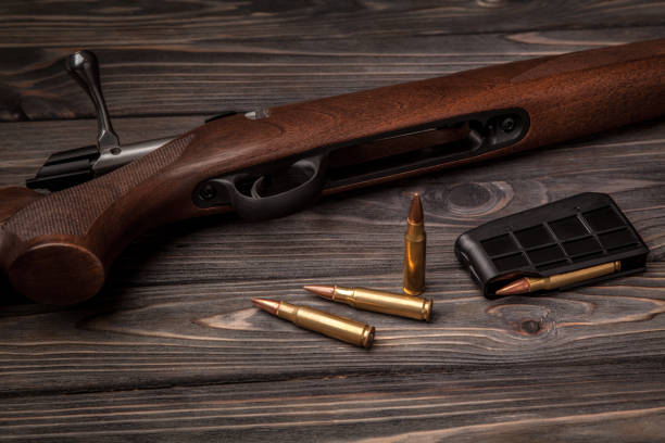 istock Hunting rifle on a dark wooden background 1141606827