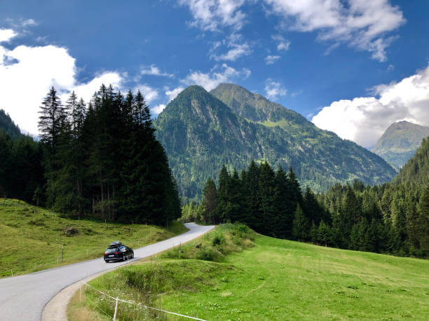 A car driving through beautiful road with big mountains in Austria A car driving through beautiful road with big mountains on Neustift im Stubaital road in Austria neustift im stubaital stock pictures, royalty-free photos & images