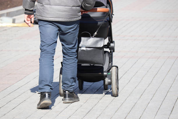 istock Man walking with a baby stroller on a street 1141612468