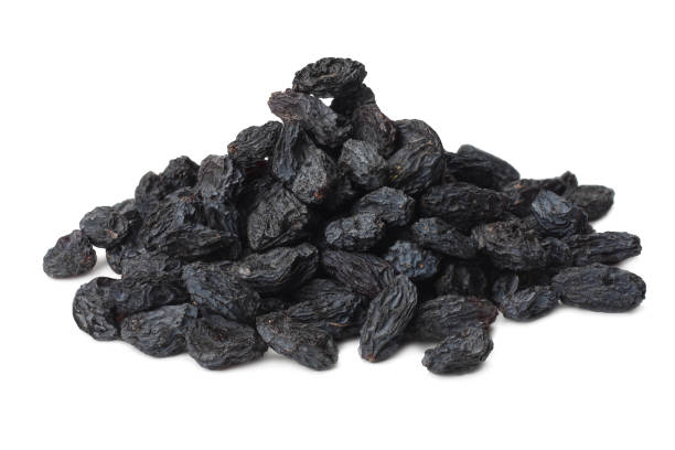 uvetta nera isolata su sfondo bianco - dried grape foto e immagini stock