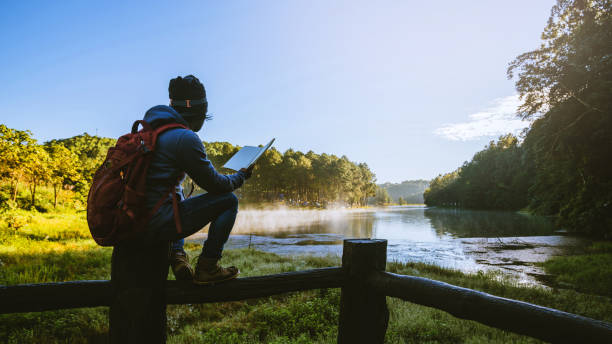 ein junger mann, der sitzt und ein buch über das holz liest, ein aussichtspunkt, der bei pang ung mae hong sohn, in thailand wunderschön ist. - writing diary nature ideas stock-fotos und bilder