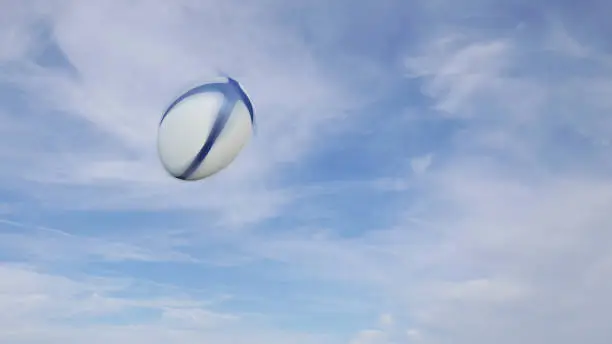 Rugby ball freeze-frame with speed blur effect on a blue sky background