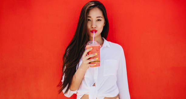 istock Young asian woman drinking juice 1141618339