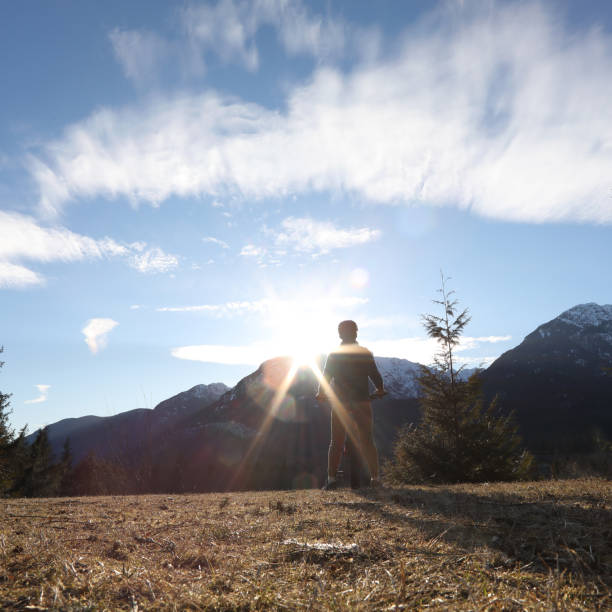 istock Mountain biker pauses on hill above valley, mountains 1141618397