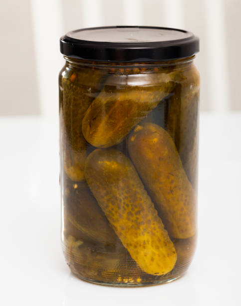 istock Glass jar with pickled cucumbers on white background 1141618439