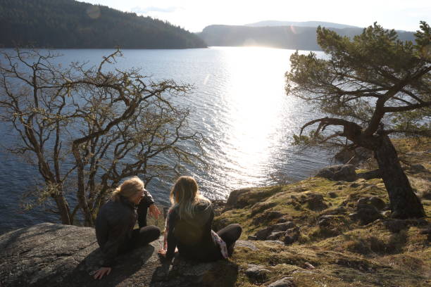 istock Female hikers relax by lakeside at sunset 1141619671