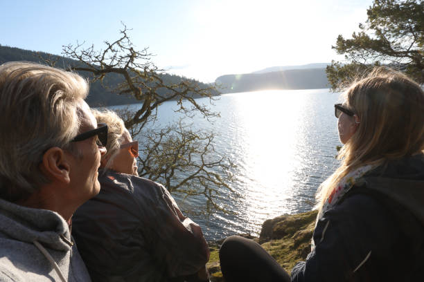 Hikers relax by lakeside at sunset