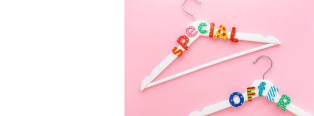 istock White hangers with sale text on pink background 1141621017