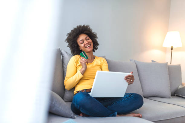 istock Woman is holding credit card and using laptop computer. 1141621263