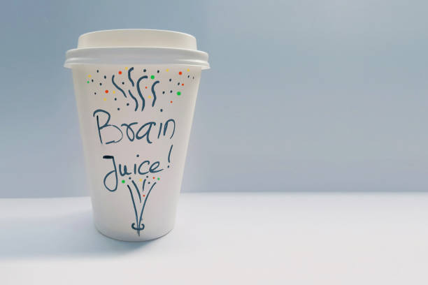 istock Disposable coffee cup with colorful decoration and brain juice text written on it. 1141621410