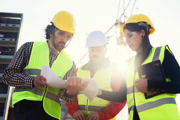 istock Young women architect explaining the blueprints to construction workers at construction site. 1141621596