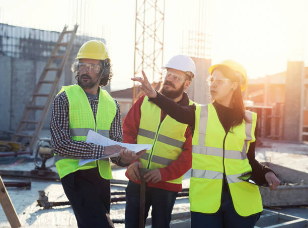 istock Young Latino architect holding digital tablet and pointing with hand the problem on construction site, group of three construction workers preparing for work, business meeting on construction site 1141621631