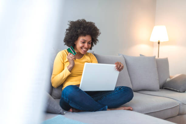 istock Woman is holding credit card and using laptop computer. 1141622695