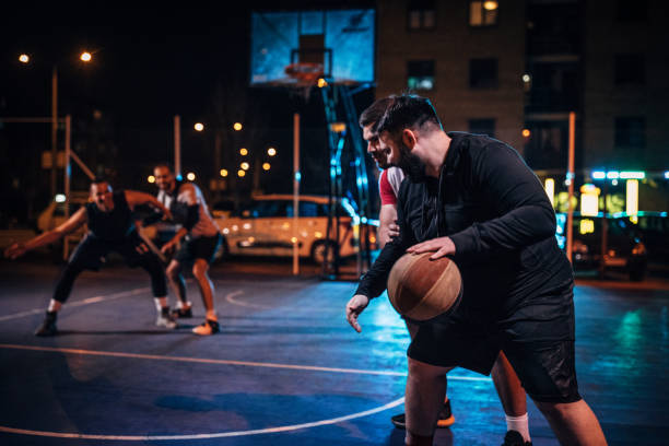 istock Friends playing basketball outdoors at night 1141623548