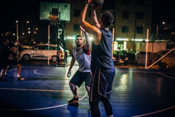 istock Men playing basketball outdoors at night 1141624850