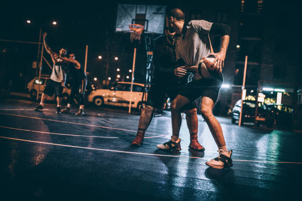 istock Friends playing basketball downtown at night 1141625279
