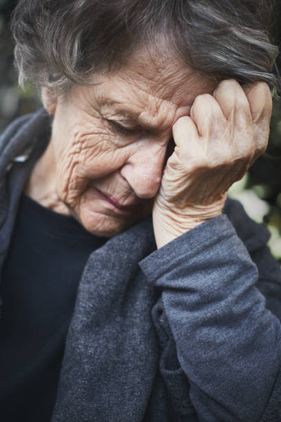istock Desperate old woman crying, head in hands 1141626928