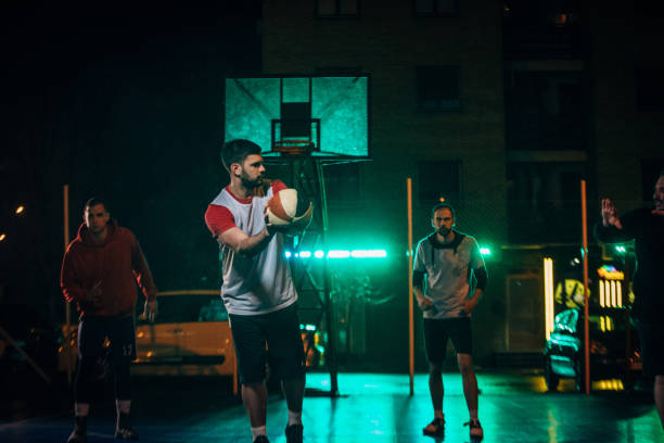 istock Guys playing basketball at night 1141627066