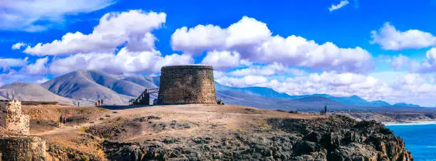 Photo of landscapes of volcanic Fuerteventura - view with Toston tower in El Cotillo. Canary islands