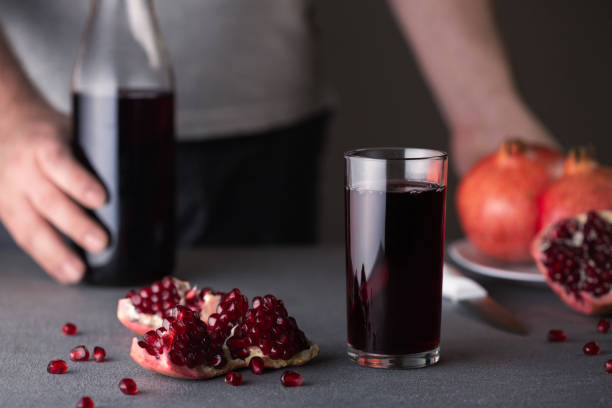istock Pomegranate juice in a glass on gray background. 1141629079