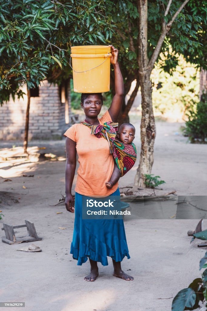African Mother with Baby Son and water bin at Home African Mother with Baby Son at Home Africa Stock Photo